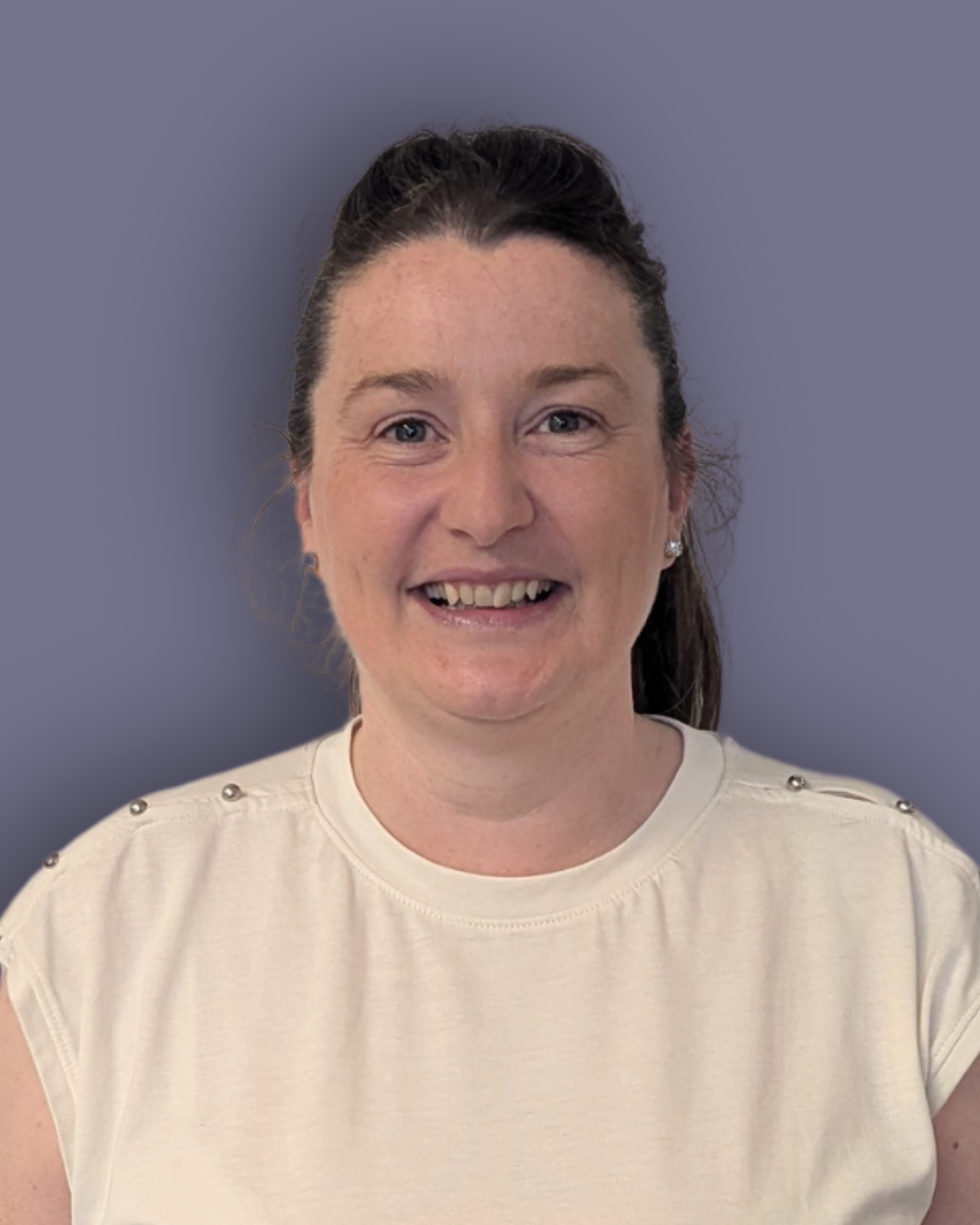 A headshot photo of Lucy Appleton against a dark lilac background. Lucy is smiling in the photo and wears a white top.