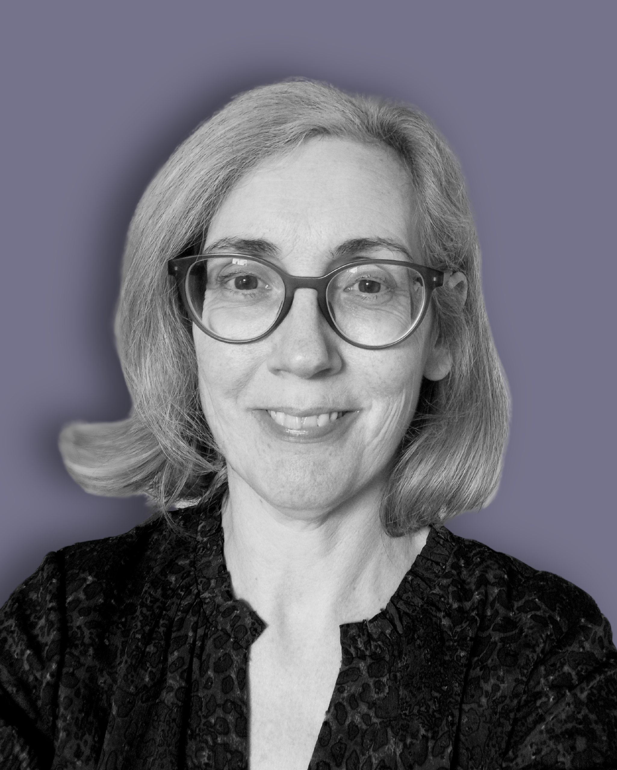 Black-and-white headshot of Louise Winterburn who has shoulder-length light hair, wearing glasses and a patterned blouse, set against a purple background. She is smiling softly, looking directly at the camera.